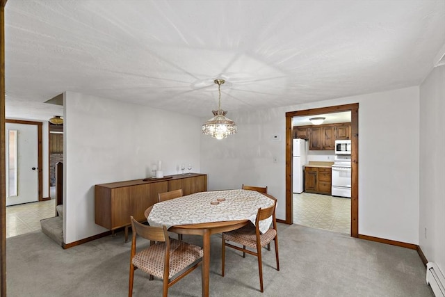 dining space with baseboards, light carpet, and a baseboard heating unit