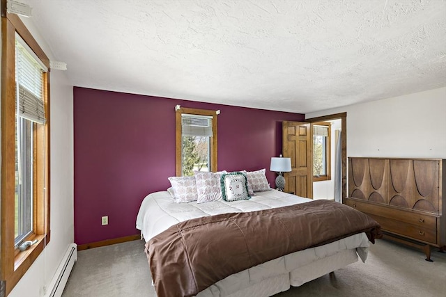 carpeted bedroom with a textured ceiling, a baseboard heating unit, and baseboards