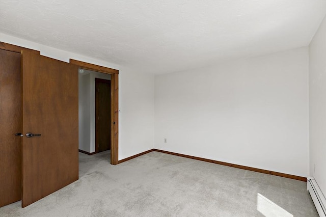 unfurnished room with baseboards, a baseboard radiator, and light colored carpet