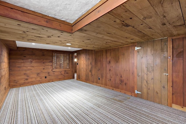 spare room with wooden ceiling, wood walls, and carpet floors