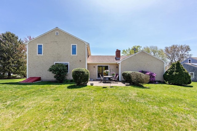 back of house featuring a patio area, a yard, and a chimney