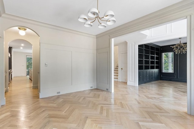 unfurnished dining area featuring light parquet floors, an inviting chandelier, ornamental molding, and a healthy amount of sunlight