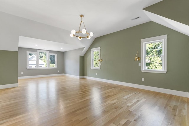 interior space featuring lofted ceiling, light wood-type flooring, and a chandelier