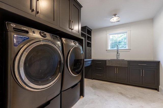 clothes washing area featuring independent washer and dryer, cabinets, and sink