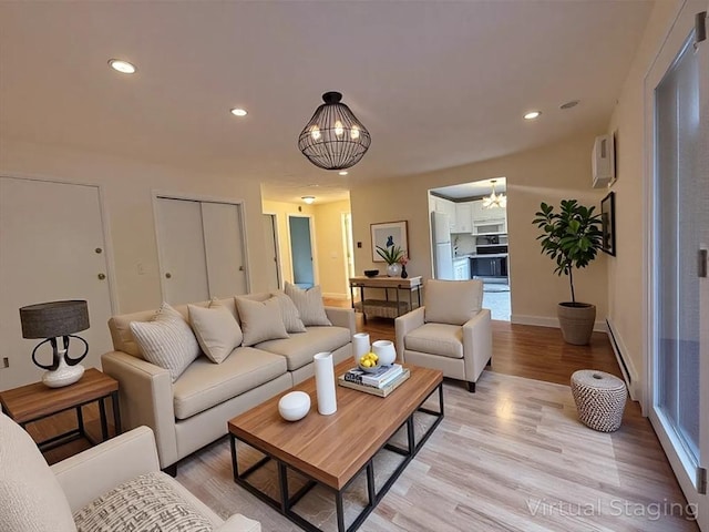 living area with recessed lighting, light wood-type flooring, baseboard heating, and a notable chandelier