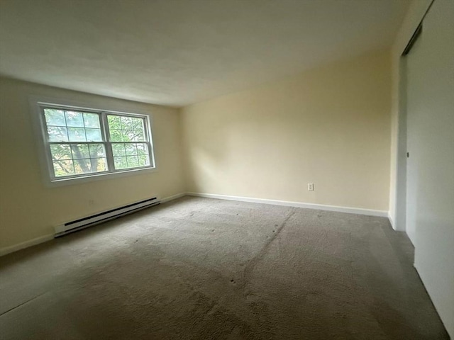 carpeted spare room with baseboards and a baseboard heating unit