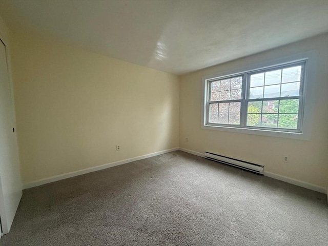 empty room with baseboards, carpet flooring, and baseboard heating