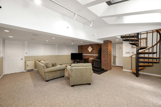 living room with rail lighting, a wood stove, light carpet, stairway, and lofted ceiling