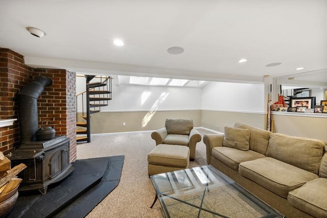 living area featuring a wood stove, carpet, stairs, baseboards, and recessed lighting