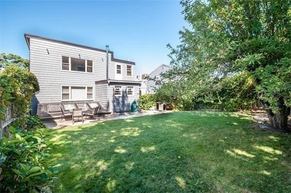 back of property featuring a patio and a lawn
