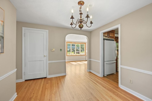 45 Donamor Ln, East Longmeadow, MA 01028 - unfurnished dining area featuring a chandelier, light wood-style floors, arched walkways, and baseboards