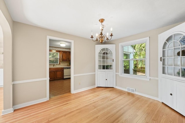 45 Donamor Ln, East Longmeadow, MA 01028 - unfurnished dining area featuring light wood-style flooring, a chandelier, baseboards, and a sink
