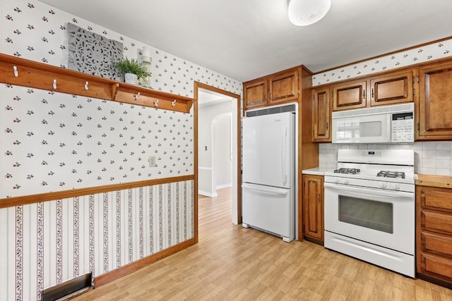 45 Donamor Ln, East Longmeadow, MA 01028 - kitchen with white appliances, wallpapered walls, brown cabinets, light wood finished floors, and light countertops