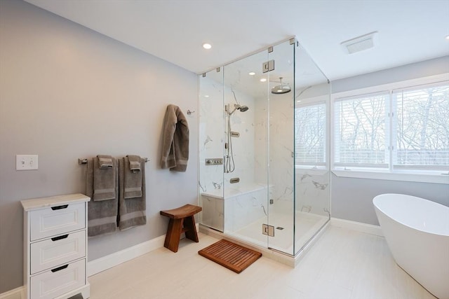 bathroom with a soaking tub, visible vents, a marble finish shower, and baseboards