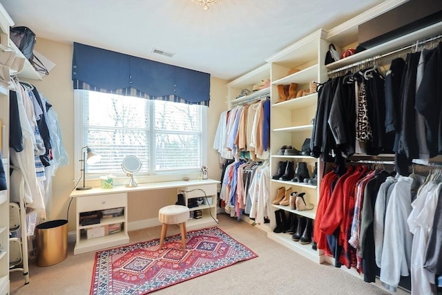 walk in closet with visible vents and light colored carpet