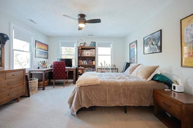 bedroom featuring light colored carpet, visible vents, and ceiling fan