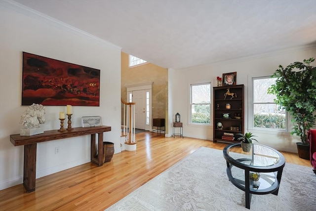 living room with crown molding, stairway, baseboards, and light wood-style floors