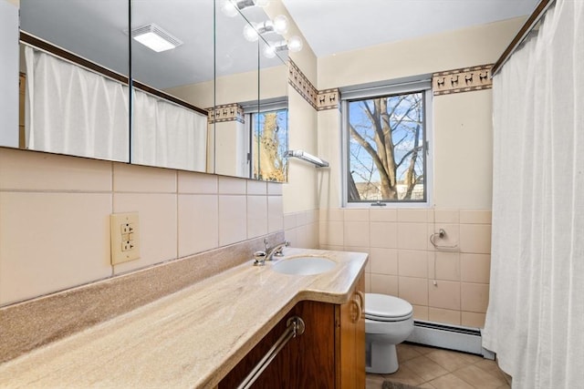 bathroom featuring vanity, a baseboard heating unit, tile patterned floors, toilet, and tile walls