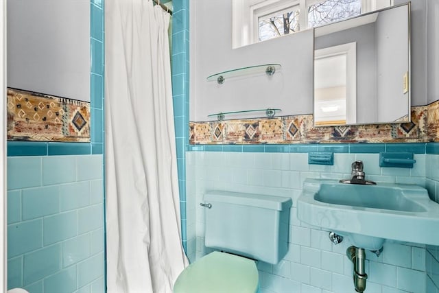 bathroom with sink, toilet, and tile walls