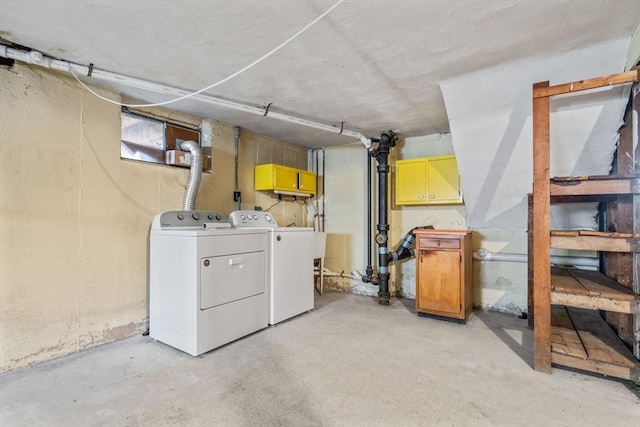 laundry area featuring washing machine and clothes dryer and cabinets