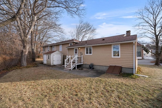 rear view of house with a storage unit and a yard