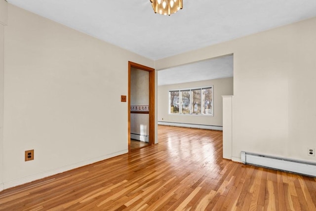 unfurnished room with light hardwood / wood-style floors and a baseboard heating unit