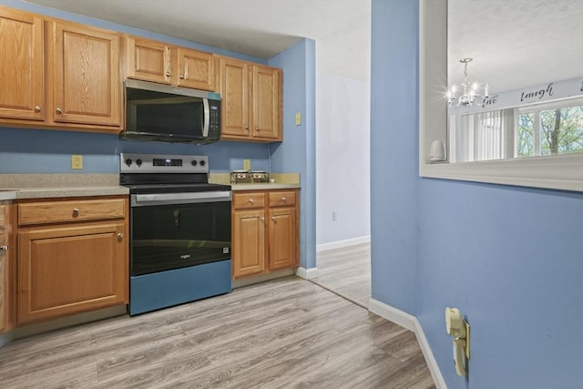 96 Caspian Way Unit 96, Fitchburg, MA 01420 - kitchen featuring stainless steel appliances, a chandelier, light countertops, and light wood-style flooring