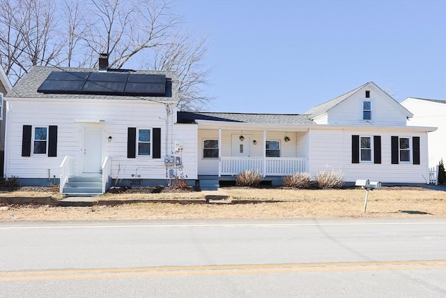 view of front of home with a porch and solar panels