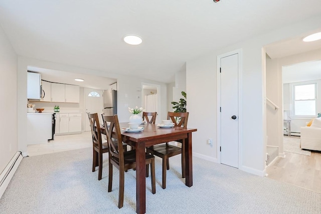 carpeted dining area featuring a baseboard radiator