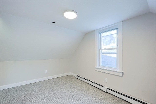 additional living space with lofted ceiling, a baseboard heating unit, and carpet