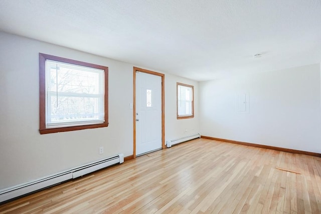 interior space with light wood-type flooring and baseboard heating