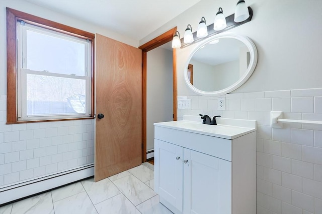 bathroom featuring baseboard heating, vanity, and tile walls