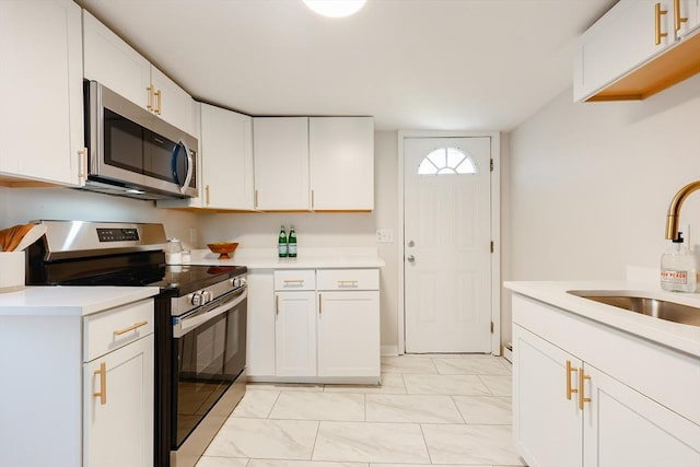 kitchen featuring stainless steel appliances, sink, and white cabinets