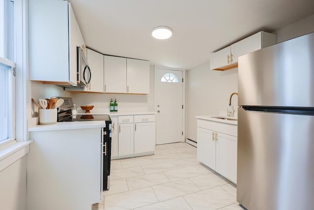 kitchen with white cabinetry, a baseboard radiator, appliances with stainless steel finishes, and sink