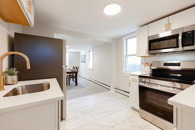 kitchen featuring a baseboard heating unit, sink, white cabinets, and appliances with stainless steel finishes