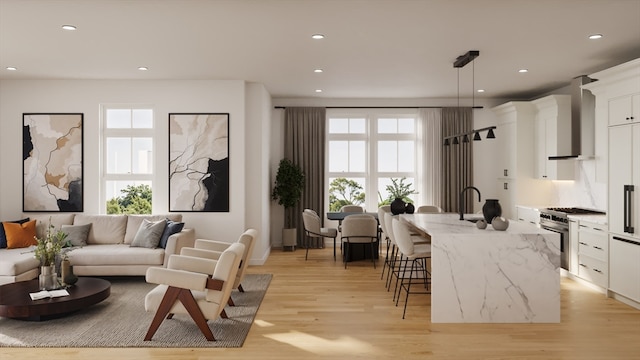 kitchen featuring white cabinetry, a wealth of natural light, pendant lighting, and light hardwood / wood-style flooring