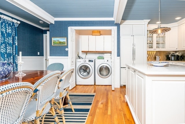 washroom with separate washer and dryer, cabinets, crown molding, and light hardwood / wood-style floors