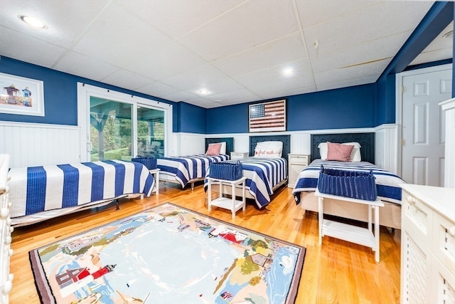 bedroom featuring a drop ceiling and hardwood / wood-style floors