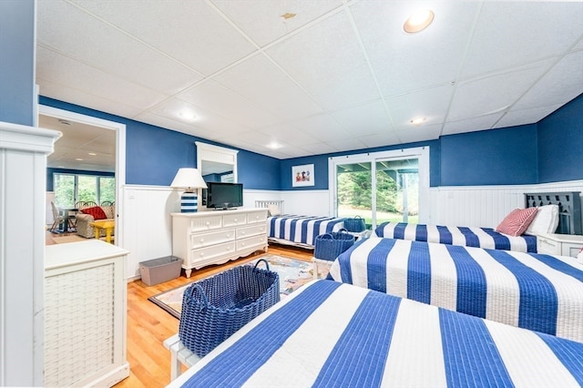 bedroom with multiple windows, hardwood / wood-style flooring, and a paneled ceiling