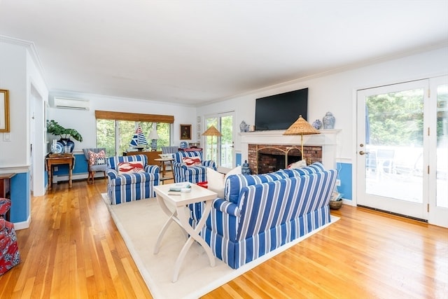 living room featuring a baseboard heating unit, a brick fireplace, hardwood / wood-style floors, a wall mounted air conditioner, and ornamental molding