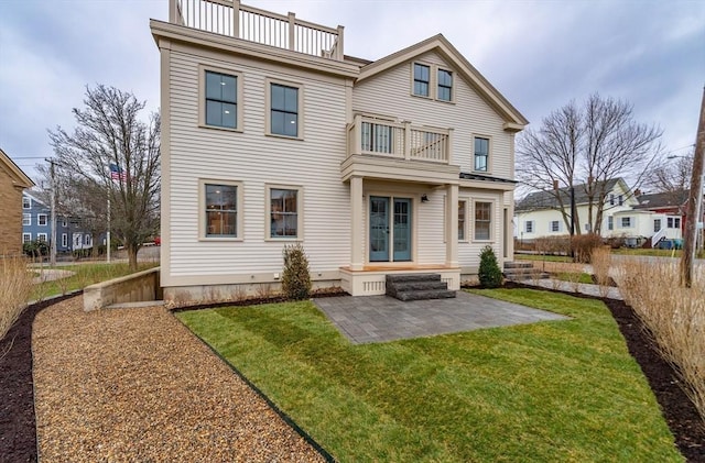 rear view of house featuring a patio area, a yard, a balcony, and fence