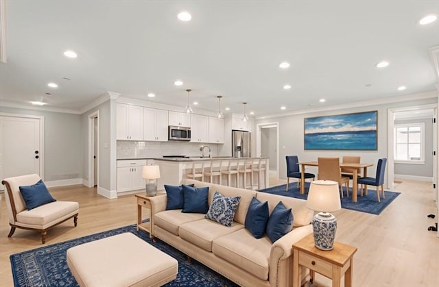 living area with crown molding, recessed lighting, baseboards, and light wood-type flooring