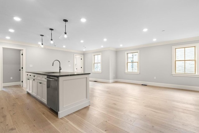 kitchen with a sink, dark countertops, ornamental molding, and dishwasher
