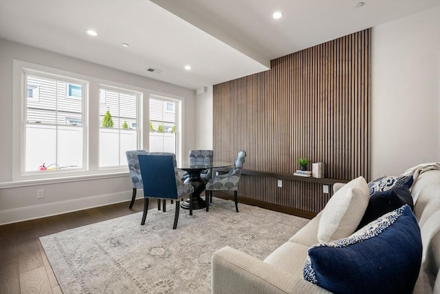 home office with baseboards, recessed lighting, wood finished floors, wooden walls, and an accent wall