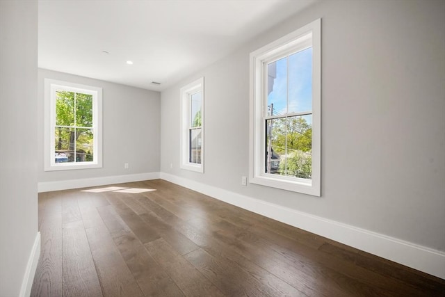 empty room featuring dark wood finished floors and baseboards