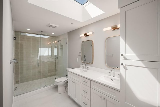 bathroom with a skylight, a stall shower, toilet, double vanity, and recessed lighting