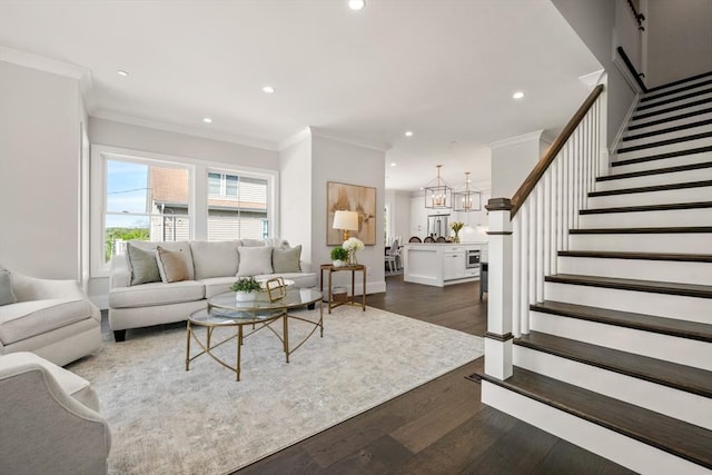 living room featuring stairs, recessed lighting, ornamental molding, a chandelier, and dark wood-style floors