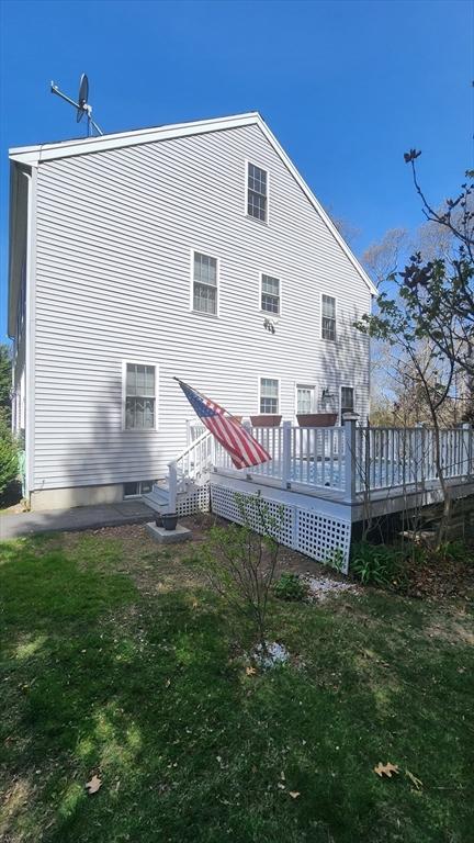 rear view of property with a lawn and a wooden deck