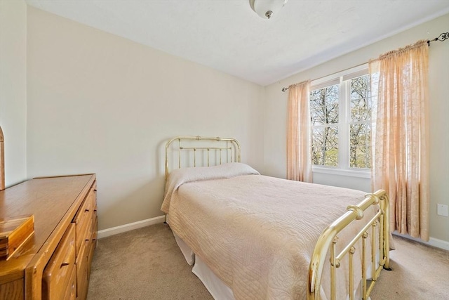 bedroom featuring baseboards and light colored carpet