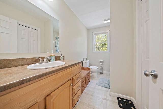 full bath with vanity, baseboards, and toilet